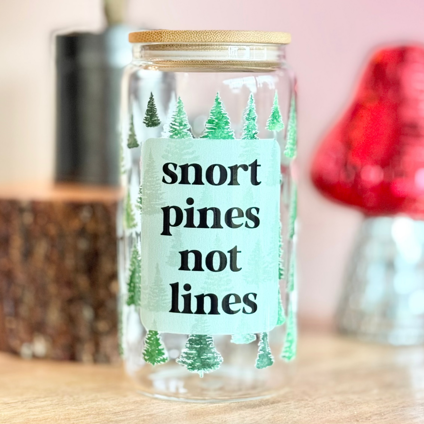 Glass jar with a humorous label on a wooden surface with decorative items in the background
