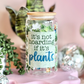 Decorative jar with 'it's not hoarding if it's plants' text, surrounded by small plants and disco balls on a pink background.