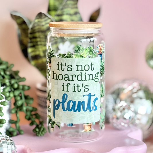Decorative jar with 'it's not hoarding if it's plants' text, surrounded by small plants and disco balls on a pink background.