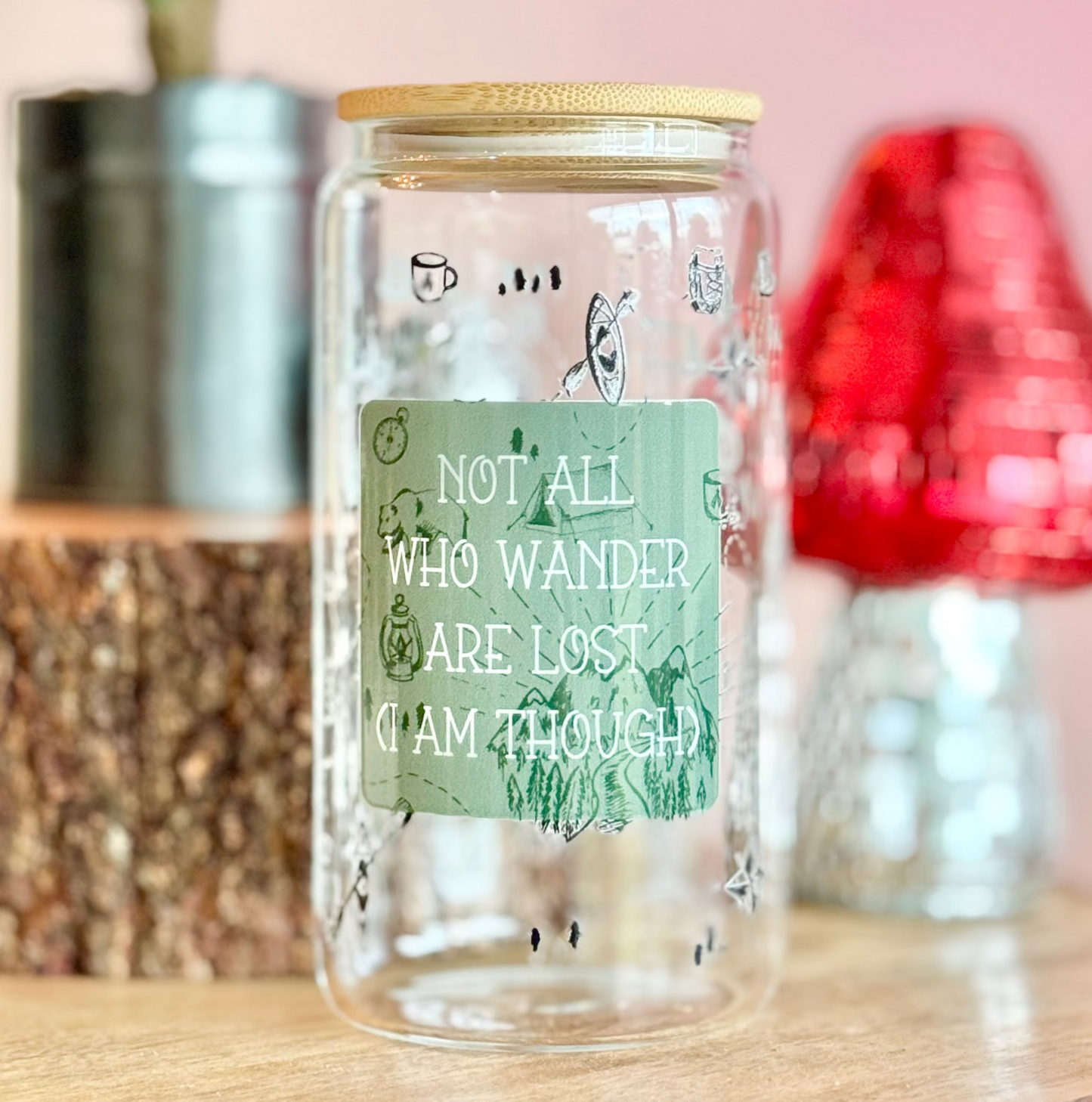 Clear glass jar with a green label on a wooden surface with decorative items in the background.