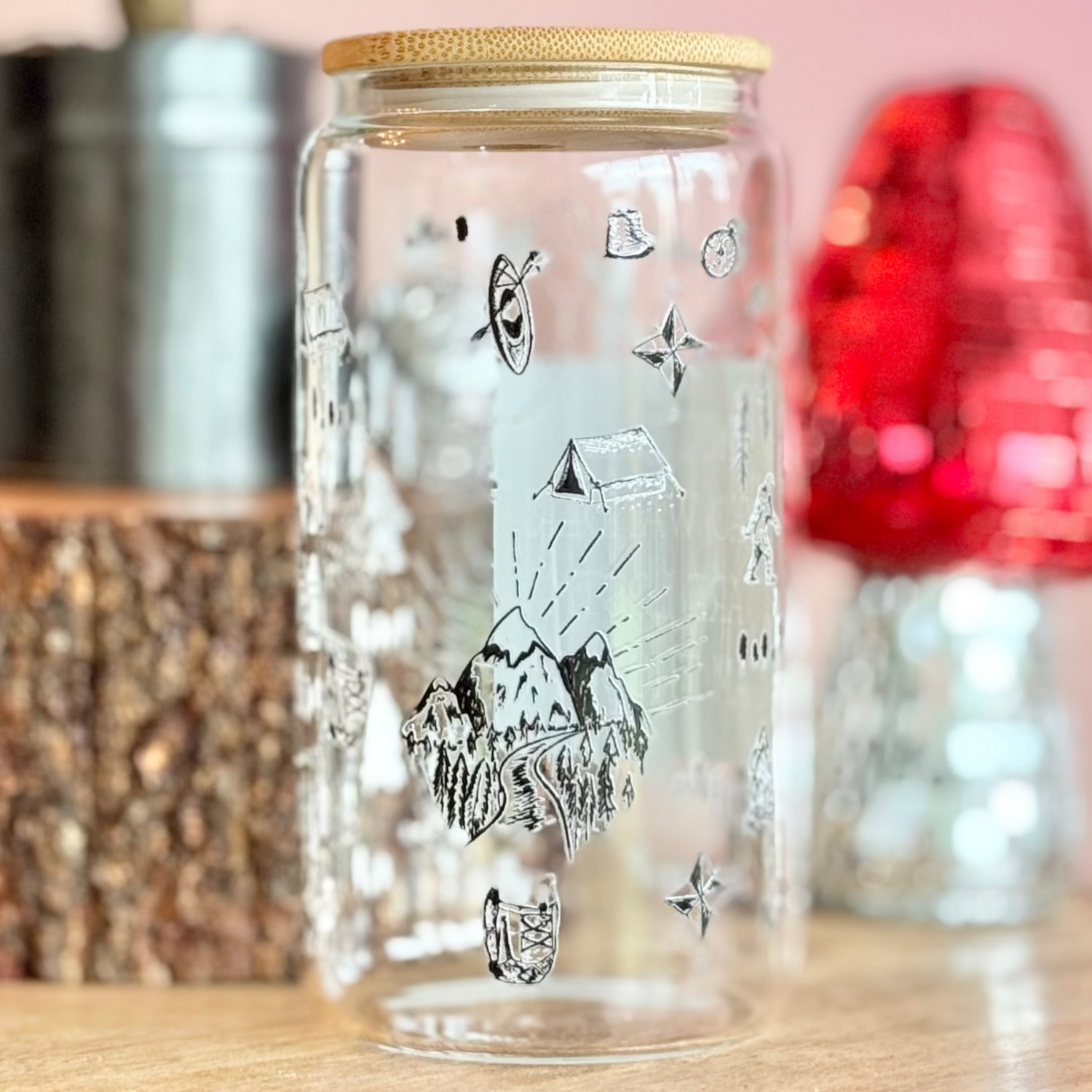 Glass jar with decorative elements on a wooden surface with a pink background