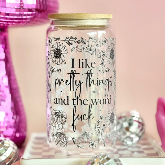 Glass jar with floral designs and text on a pink background