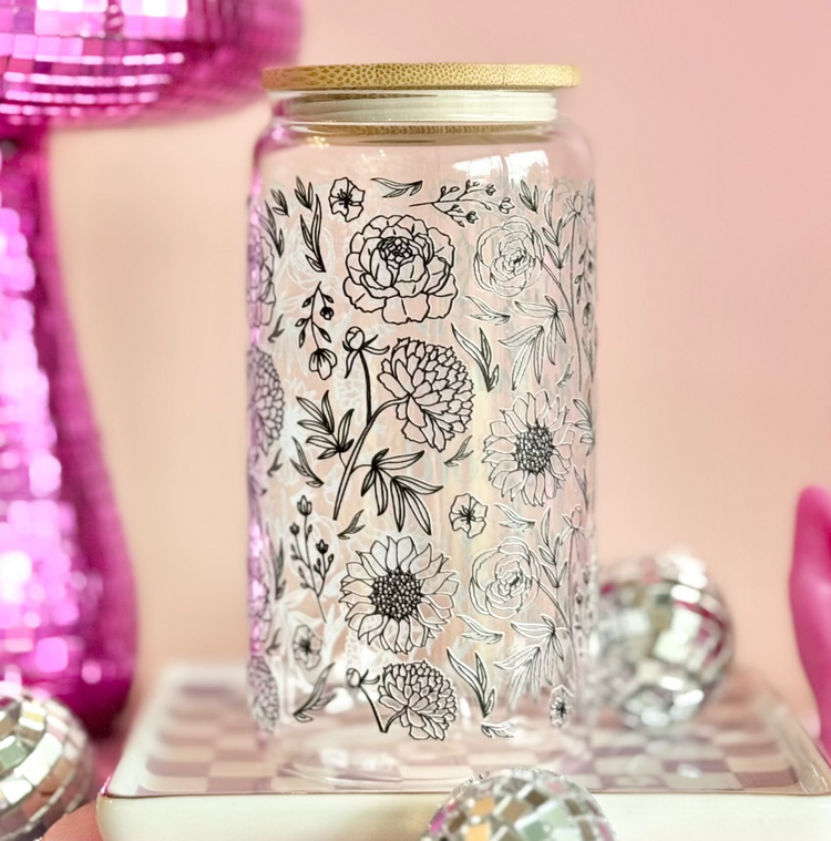 Decorative jar with floral design on a pink background with disco ball and string lights.