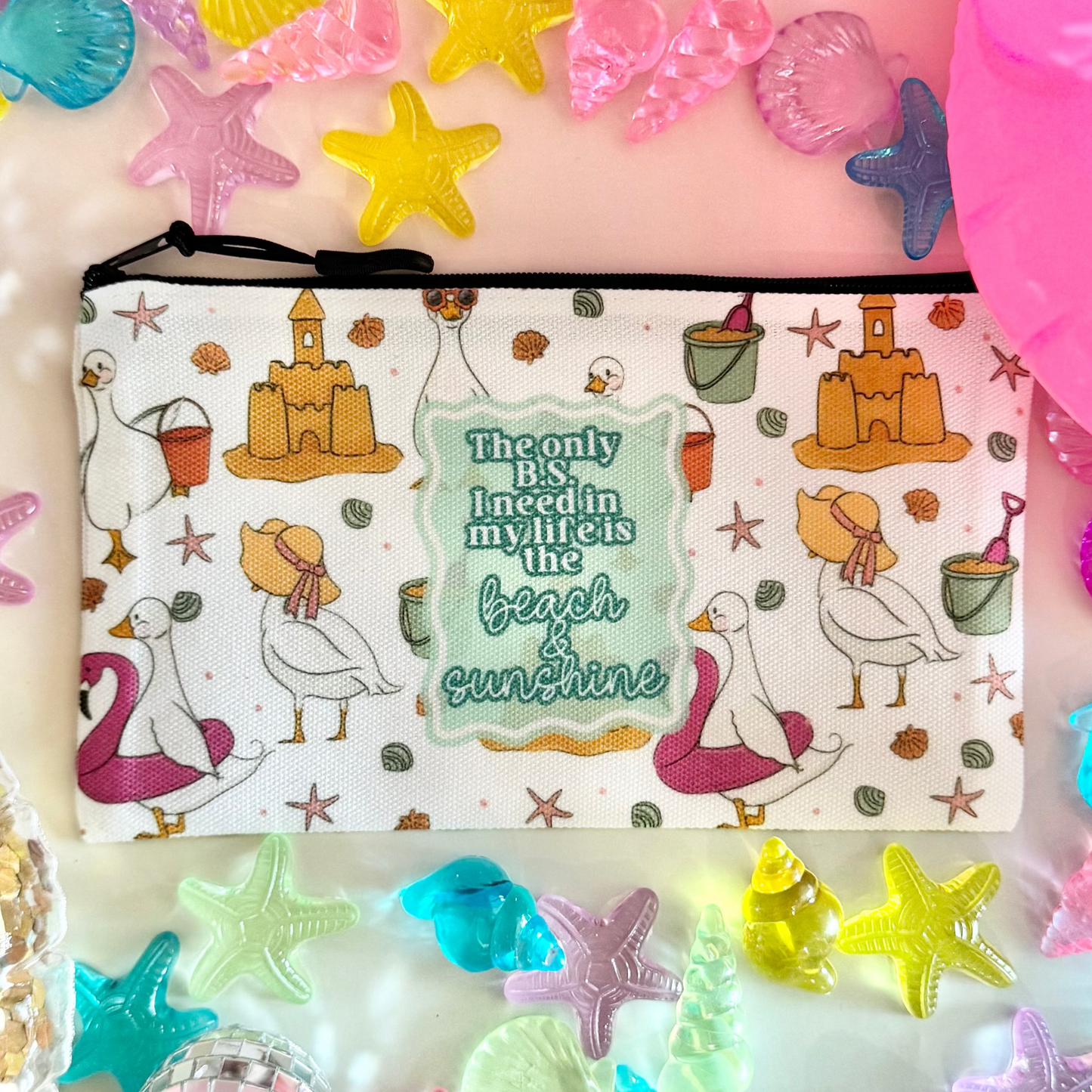 Colorful accessories including a pouch with cartoon designs, star-shaped objects, and a pink inflatable ring on a light background.