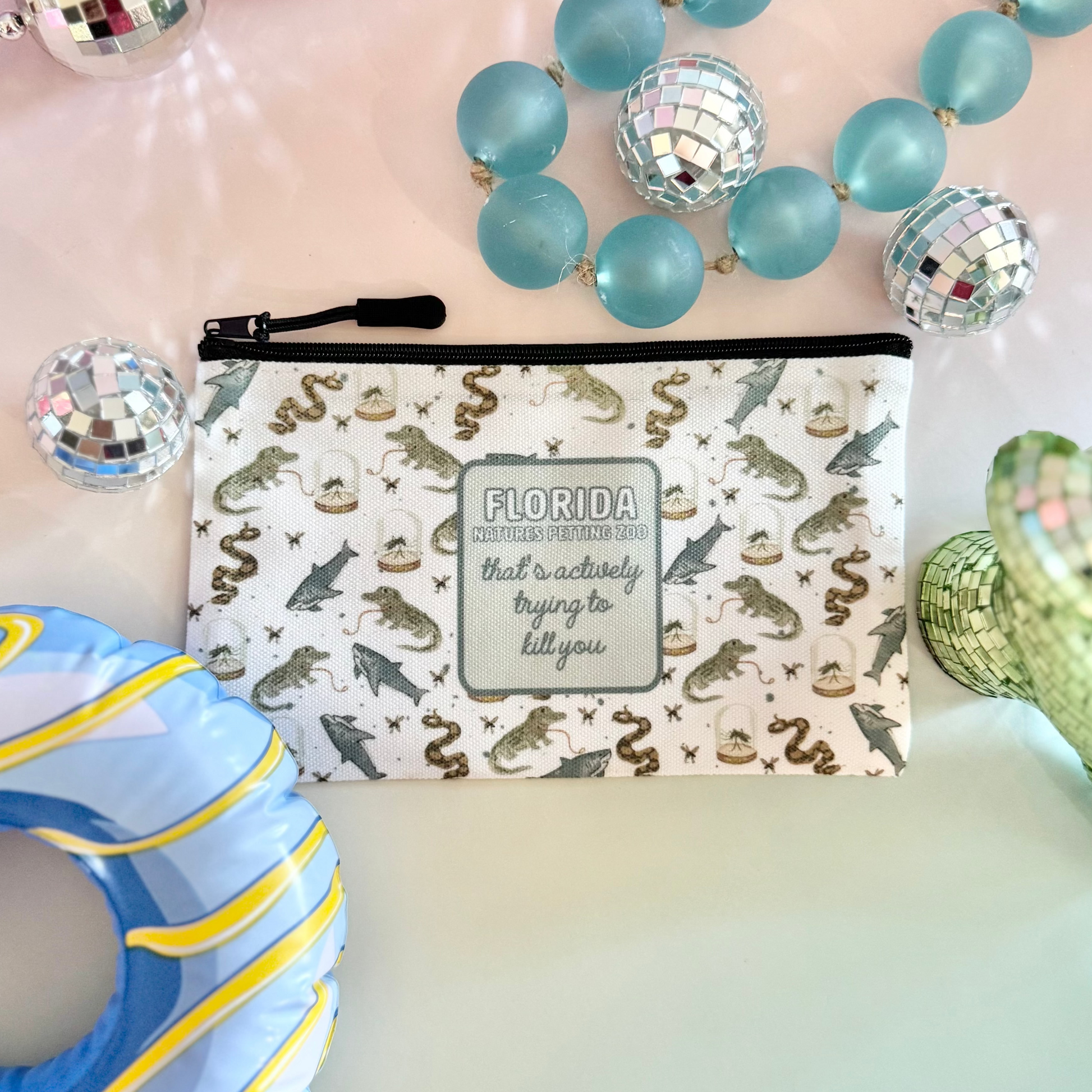 Colorful beaded necklaces, a decorative pouch with 'Florida' text, and a blue donut-shaped object on a gradient background.