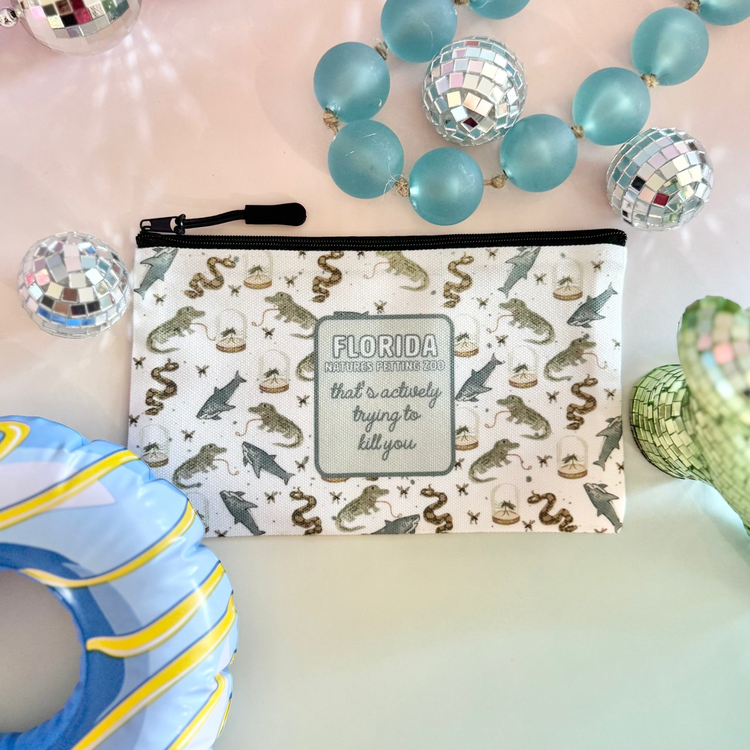 Colorful beaded necklaces, a decorative pouch with 'Florida' text, and a blue donut-shaped object on a gradient background.